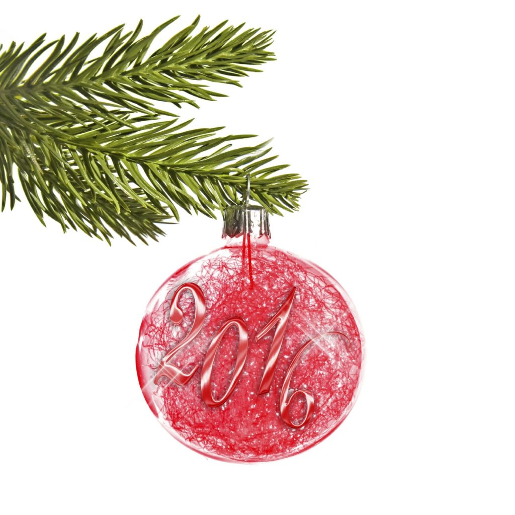 2016 on a red christmas ball hanging from a branch isolated on white