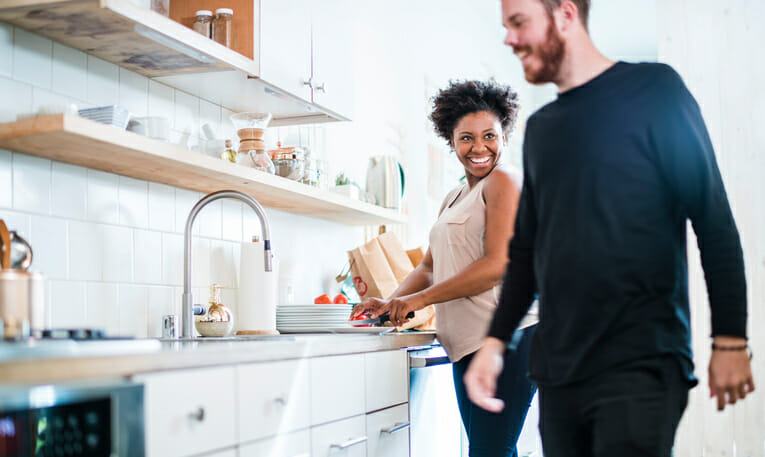 Young pretty black woman make soup in kitchen