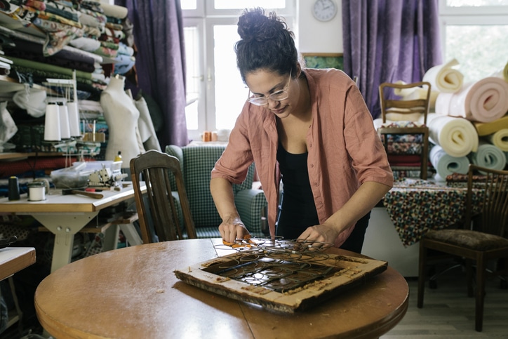 Craftswoman Preparing Chair Seat For Reupholstery