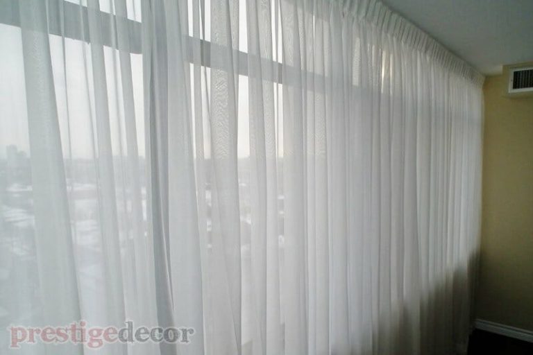 Elegant sheers in the master bedroom of a condominium in Toronto. Covering a corner window