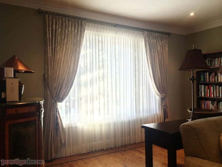 These functional curtains with tiebacks, sheers and iron decorative drapery hardware helped add privacy and made this living room look wonderful!